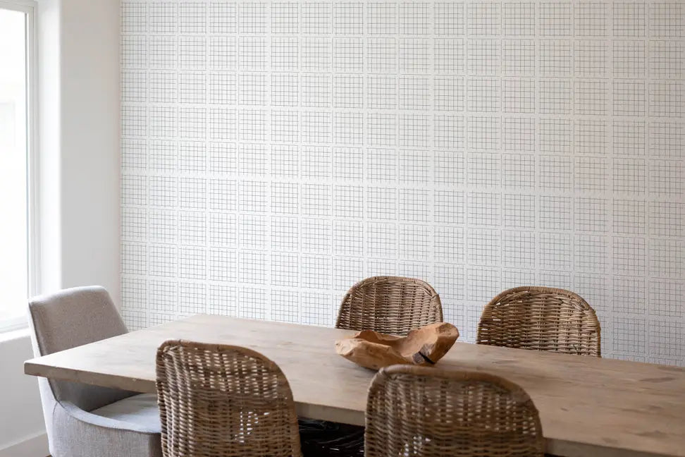 Sophisticated gray grid wallpaper in a modern dining room with a rustic wooden table and woven chairs.