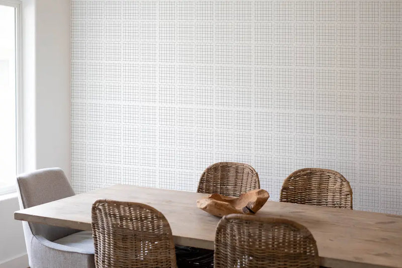 Sophisticated gray grid wallpaper in a modern dining room with a rustic wooden table and woven chairs.