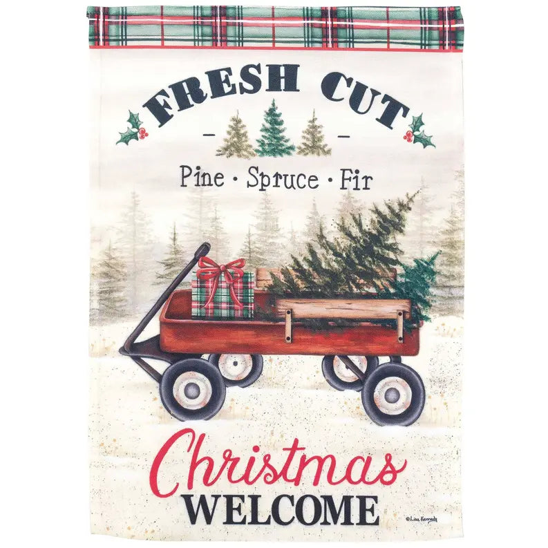 Christmas welcome garden flag featuring a red wagon with a tree, plaid accents, and text on a cream background.