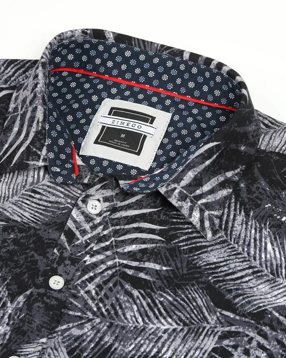 Black and white palm leaf print short-sleeve shirt with a contrasting navy polka dot collar and red accents.
