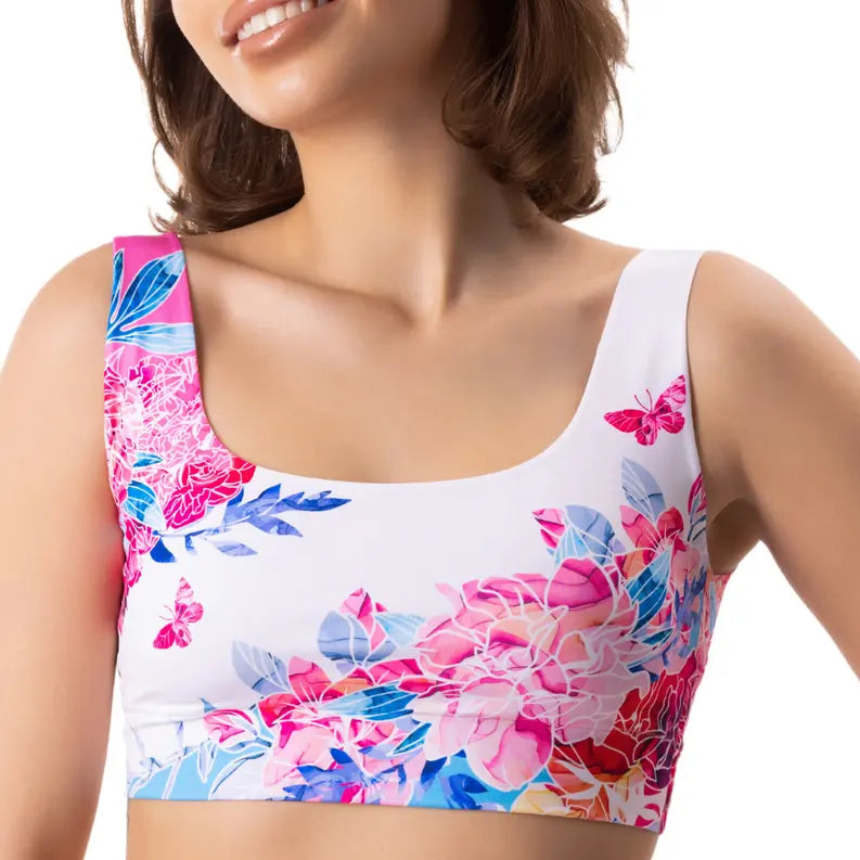Floral print crop top in white, featuring vibrant pink and blue flowers, perfect for summer style and comfort.