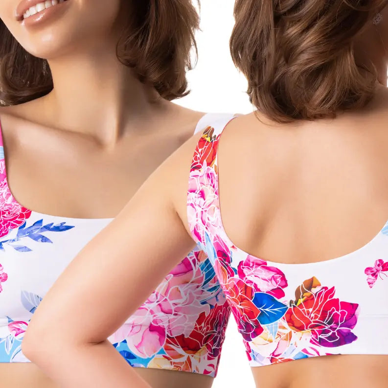 Floral print sports bra in white, featuring vibrant pink and blue flowers, perfect for activewear or casual style.